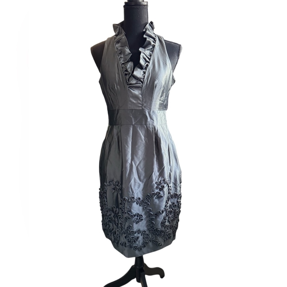 “Elegant grey dress with halter neck and ruffle details. It features a fitted